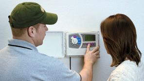 Haltom City sprinkler repair specialist shows a homeowner how to operate her new Rain Bird timer